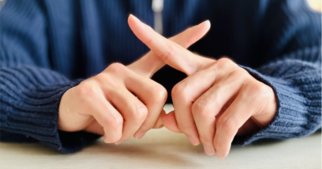 手で×（バツ）をする