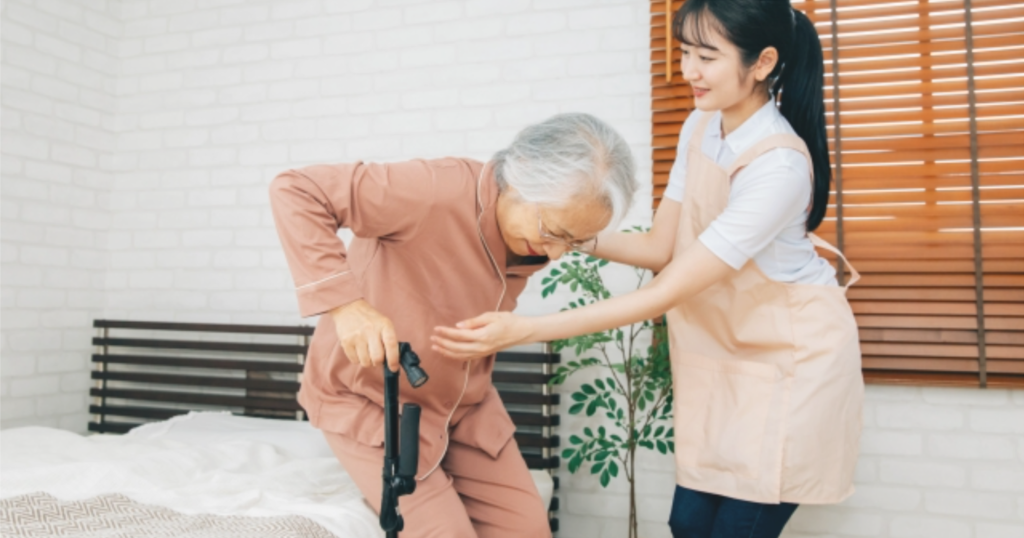介護者が立ち上がる利用者をサポートする