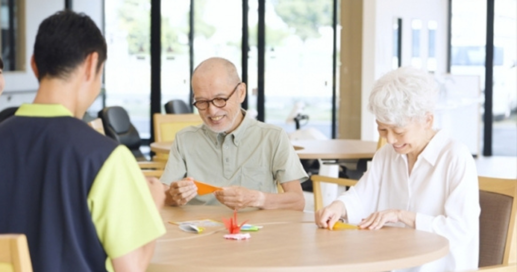 スタッフ・利用者同士で折り紙を折っている