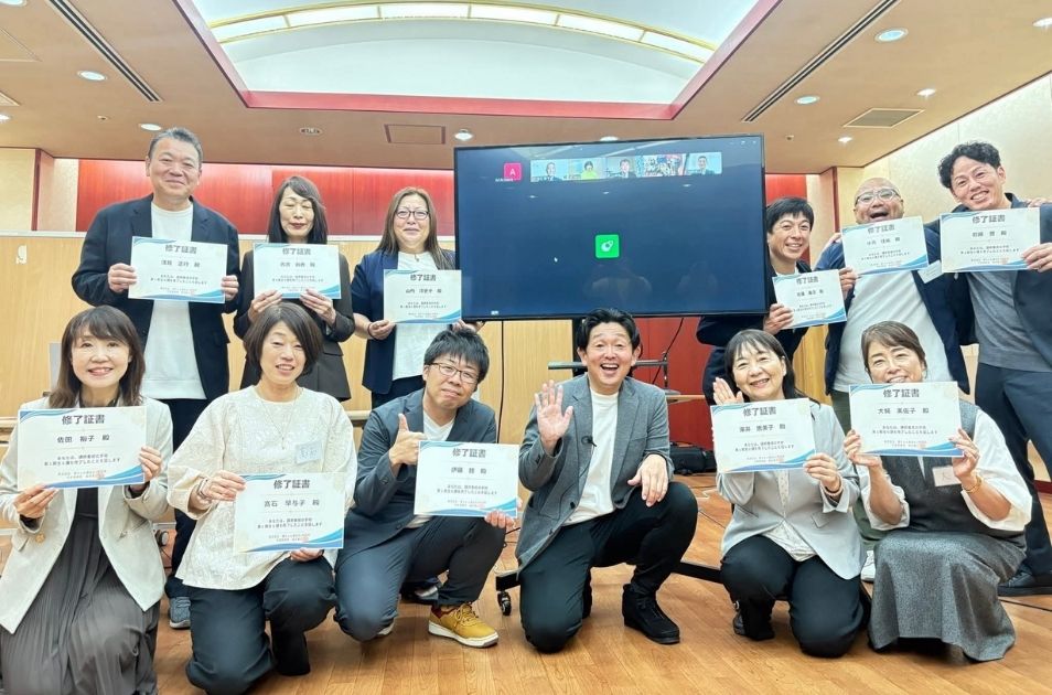 『講師養成スクール』の修了証書を手に、晴れやかな笑顔を見せる参加者たちと福井さんの集合写真
