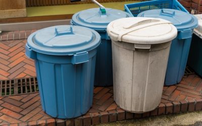 屋外に並んで置かれた、青色と白色の2つのフタ付きゴミ箱（ポリバケツ）の写真。高齢者のゴミ出し支援や生活課題を連想させるニュース記事用のアイキャッチ画像。