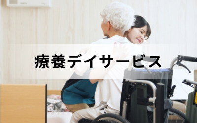 療養デイサービスで介護士が車椅子利用者をサポートしている場面。専門的なケアと温かい雰囲気が特徴の介護サービス