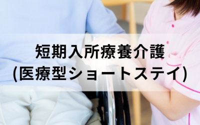 介護スタッフが車椅子に座っている利用者の手を握っている