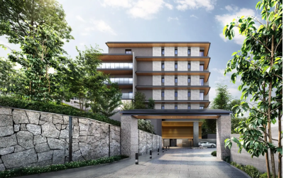 愛知県名古屋市千種区田代町に建設されるシニア向け新築分譲マンション「デュオセーヌ覚王山」の完成外観予想CG。豊かな緑と石積みの壁に囲まれた、高級感のあるエントランスアプローチ。