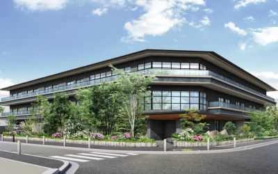 京都府にオープン予定の施設「プレザングラン京都下鴨」の外観完成予想図。豊かな緑の植栽に囲まれた、ダークグレーを基調とする高級感のある3階建ての建物のイメージ。