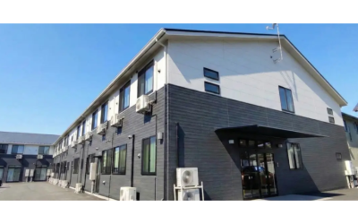 サービス付き高齢者向け住宅「アンジェス上溝」の外観写真。青空の下に建つ、白とダークグレーのツートンカラーの2階建て建物のイメージ。