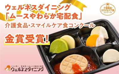 淡いピンク色の背景に、『ウェルネスダイニング ムースやわらか宅配食』が『介護食品・スマイルケア食コンクール』で『金賞受賞！』したことを知らせる文字と、お弁当容器に入ったムース食の写真が配置されたアイキャッチ画像。